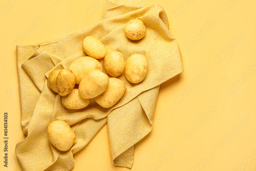 Raw baby potatoes on yellow background