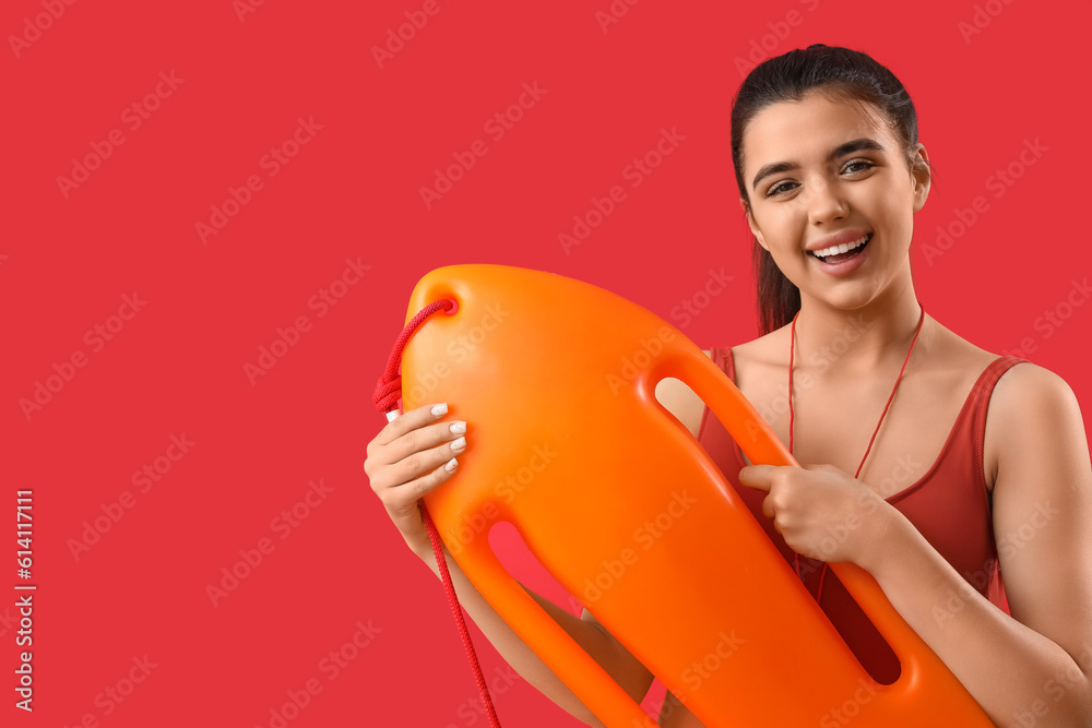 Female lifeguard with rescue buoy on red background