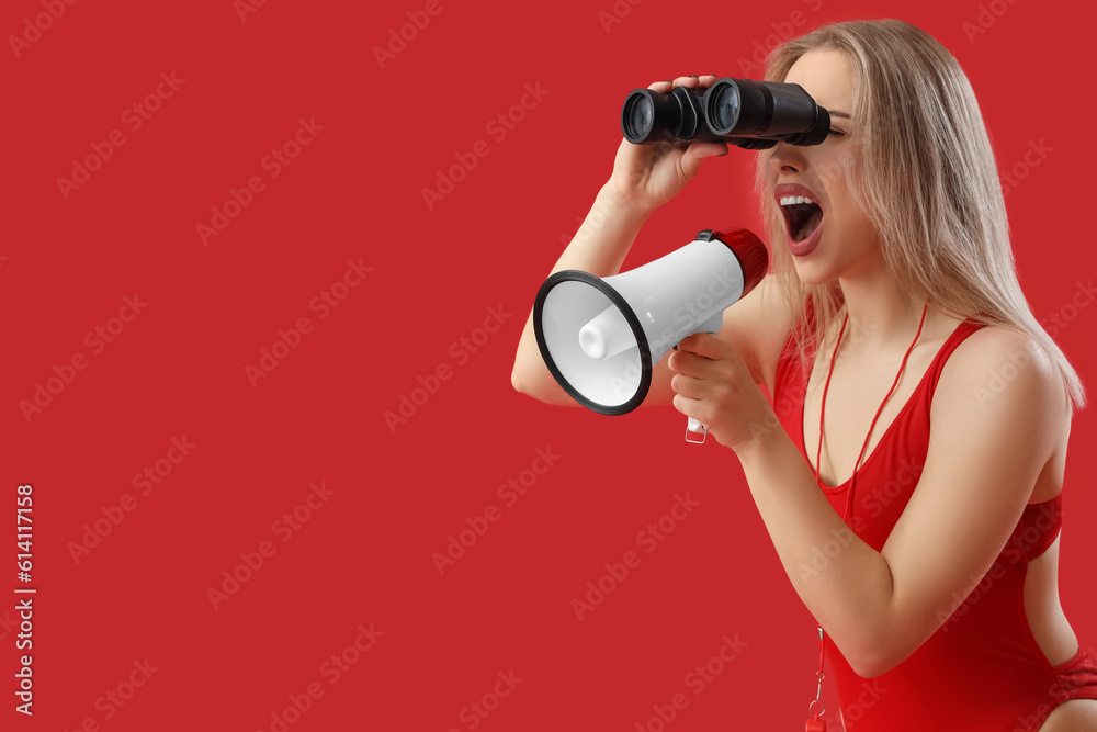 Female lifeguard with binoculars shouting into megaphone on red background