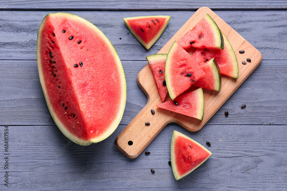 Board with pieces of fresh watermelon and seeds on blue wooden background