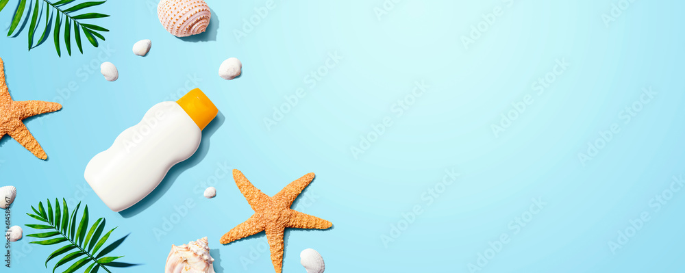 Sunblock bottle with starfish and seashells - flat lay