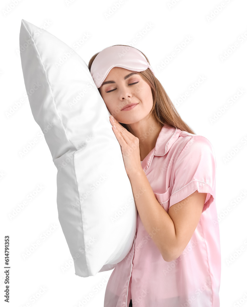 Beautiful woman in pajamas with pillow on light background