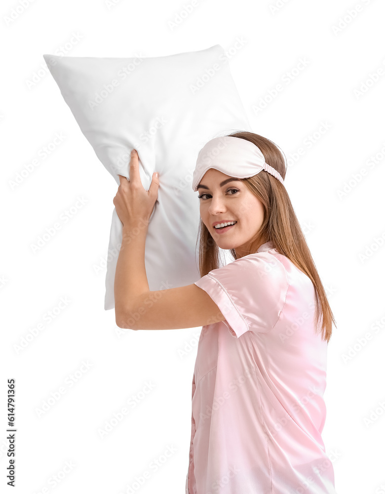 Beautiful woman in pajamas with pillow on light background