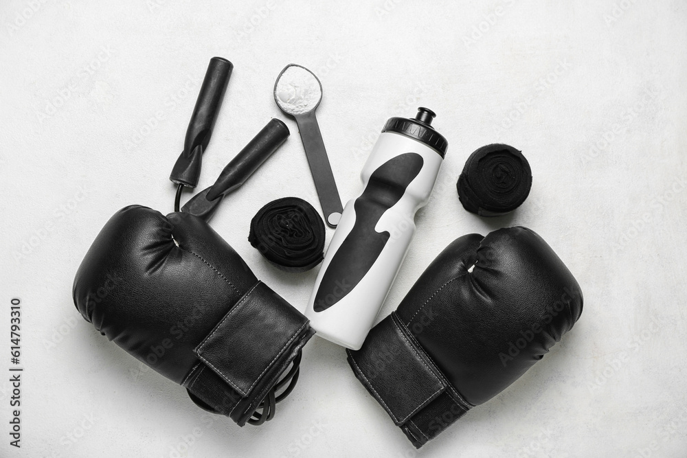 Sports equipment, bottle of water and amino acid powder on light background