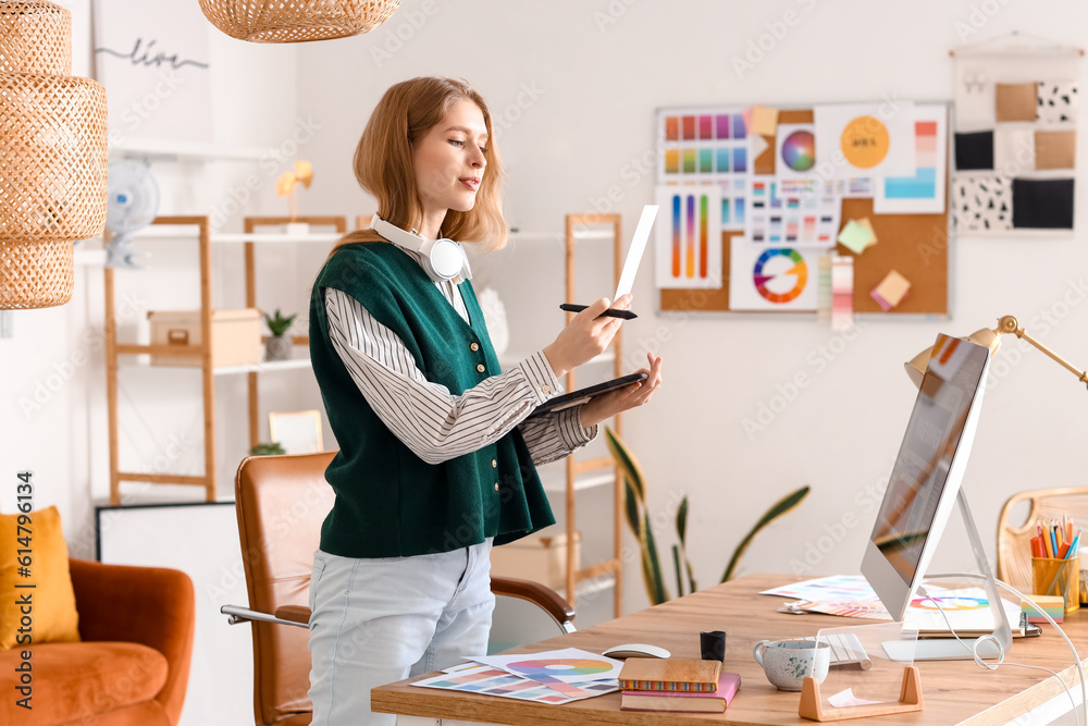 Female graphic designer working with tablet at table in office