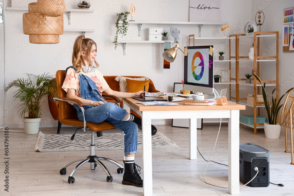 Female graphic designer working with tablet at table in office