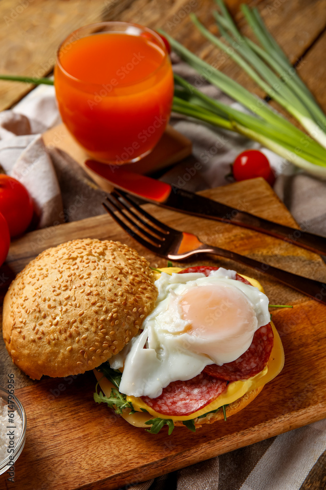 Wooden board with tasty egg Benedict on table