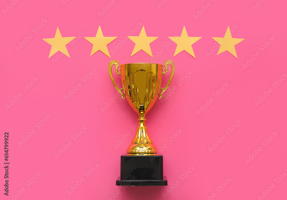 Gold cup with stars on pink background