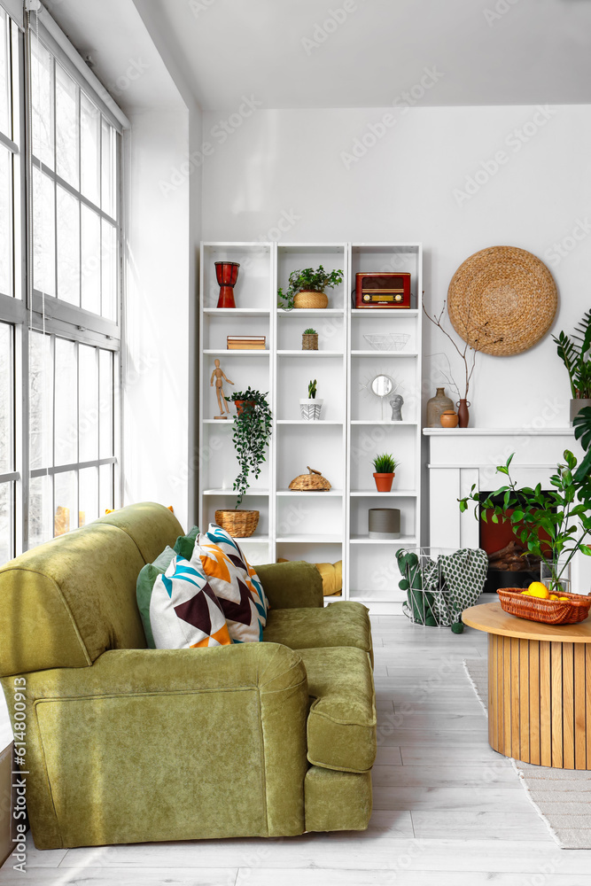 Interior of bright living room with cozy sofa and coffee table near big window