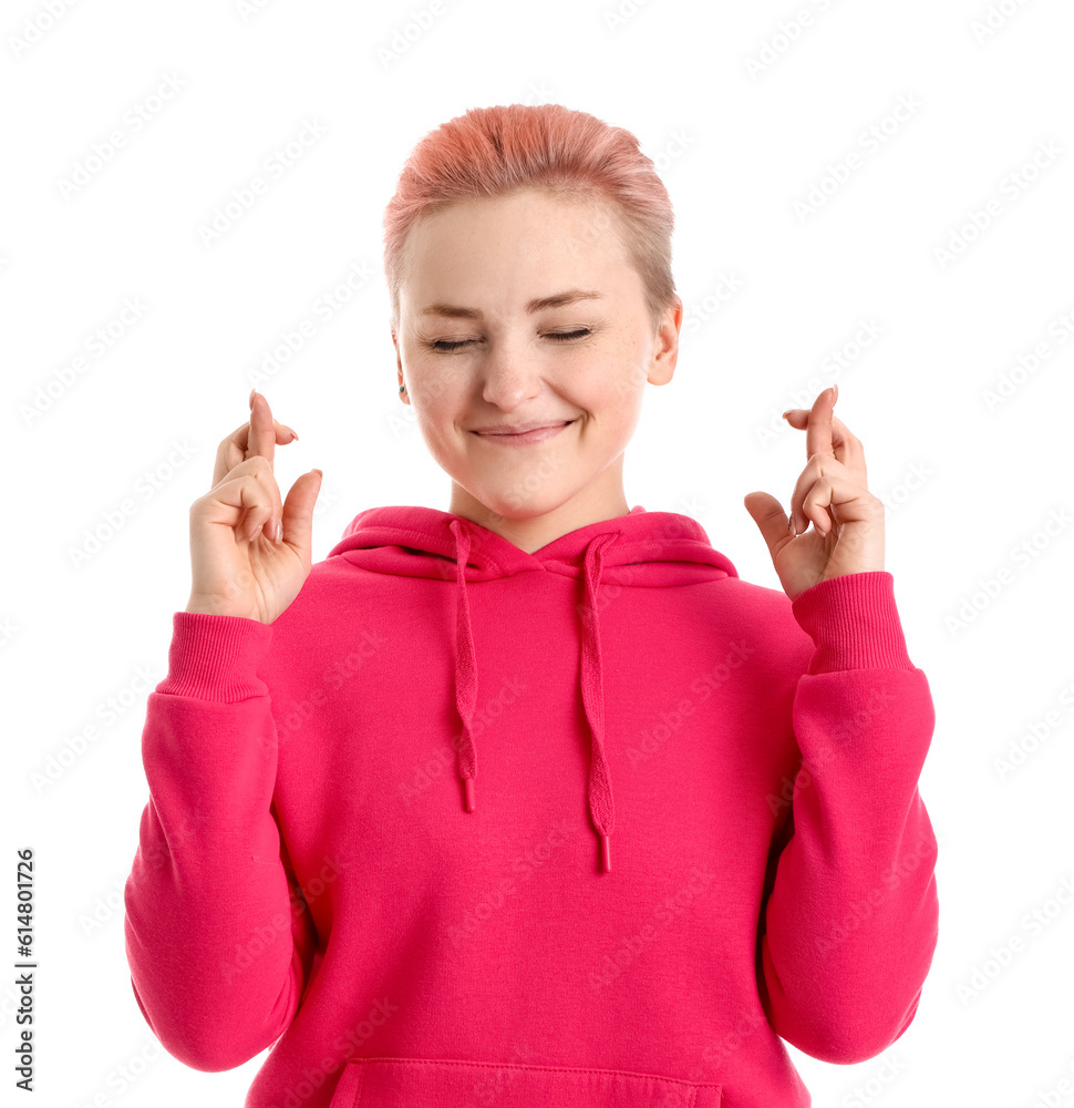 Young woman crossing fingers on white background