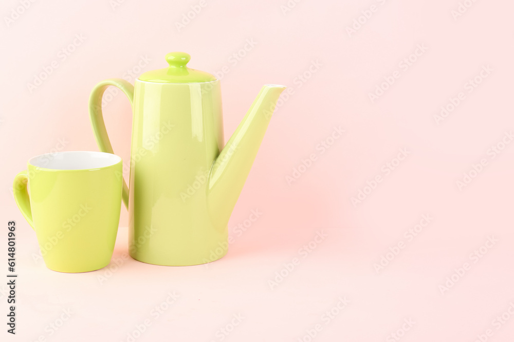 Teapot and mug on pink background