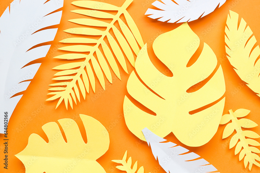 Paper tropical leaves on orange background