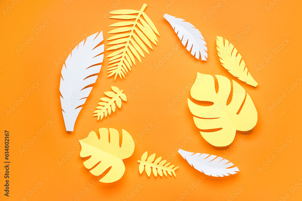 Frame made of paper tropical leaves on orange background