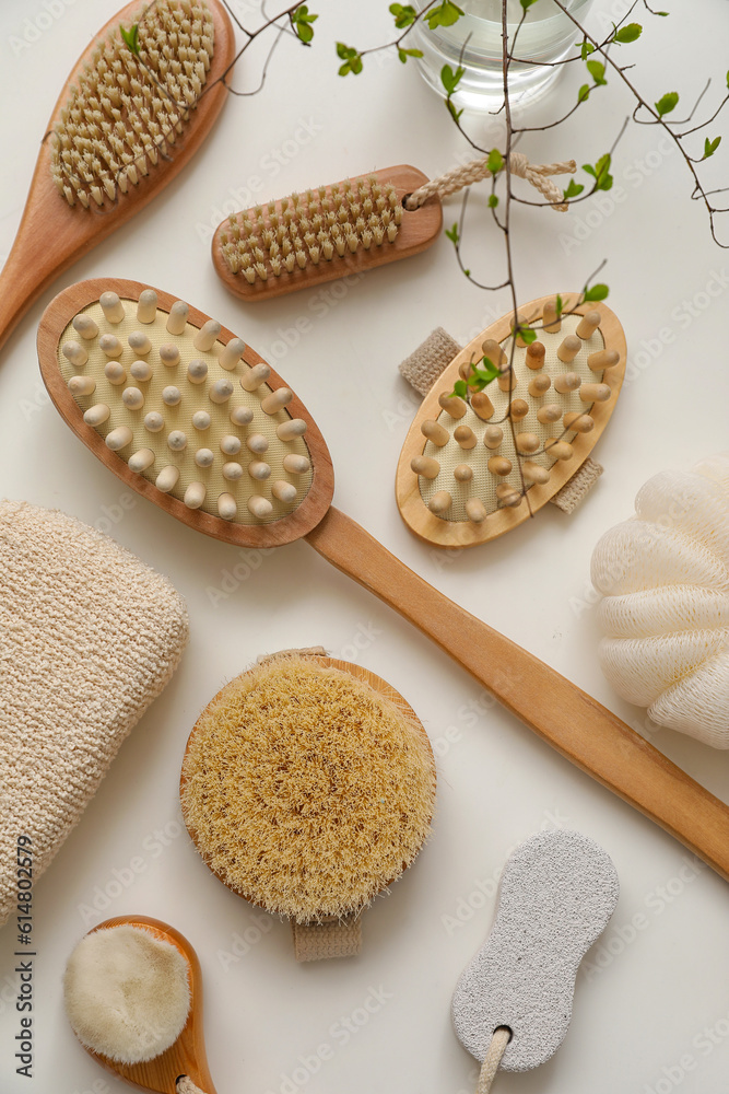 Bath accessories with massage brushes on white table, top view