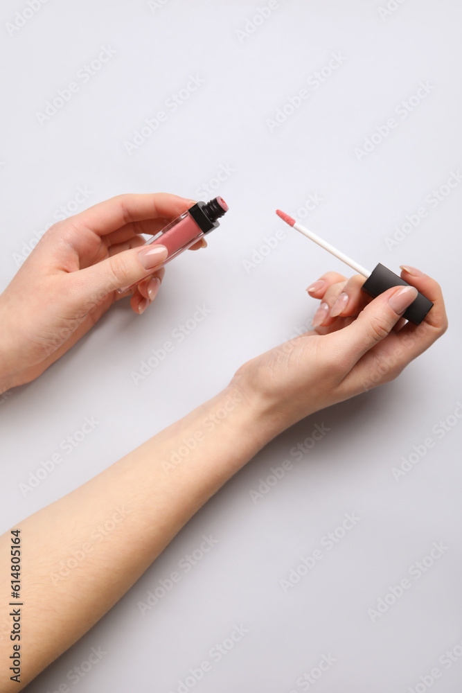 Woman with lipgloss on light background