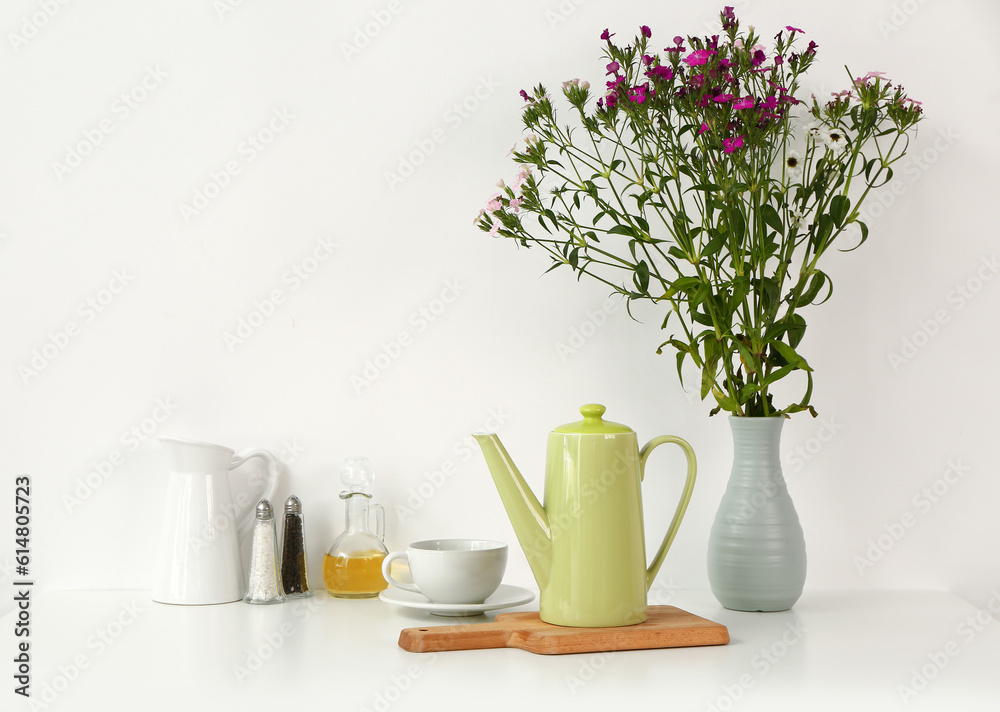 Composition with teapot, cup and different items on white table