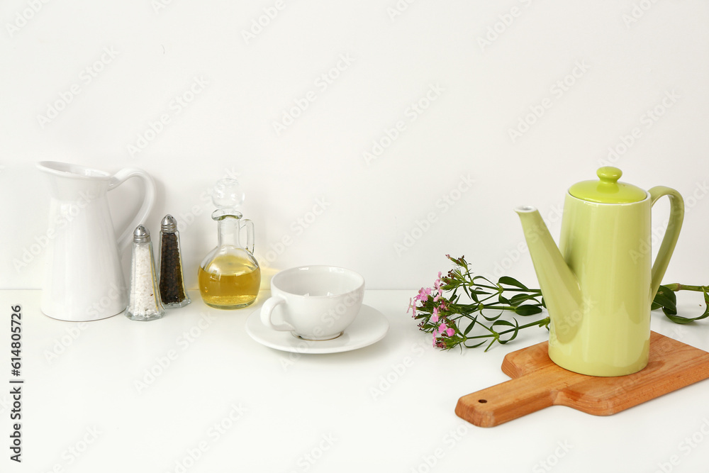 Composition with teapot, cup and different items on white table