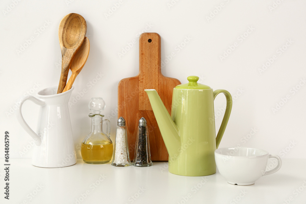 Composition with teapot, cup and different items on white table