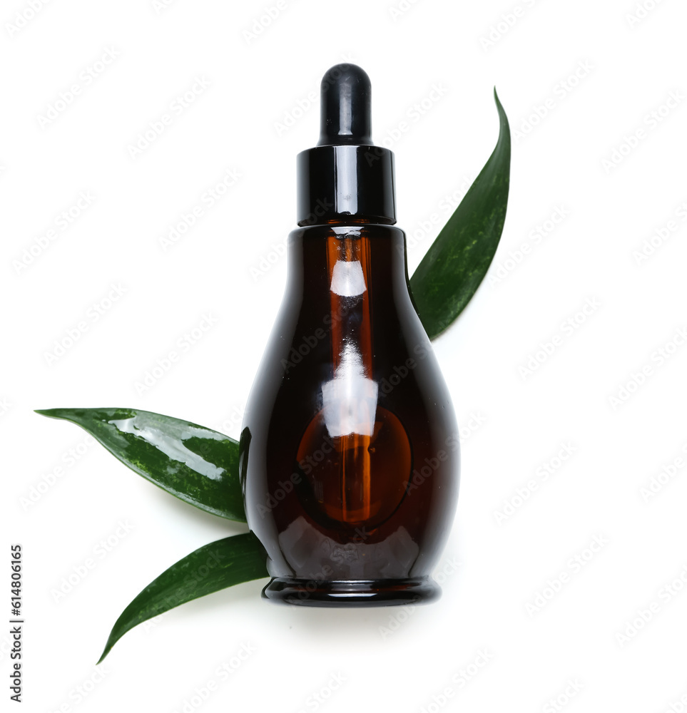 Bottle of cosmetic oil with plant twig on white background