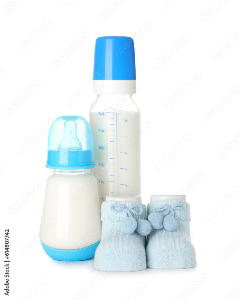 Bottles of milk for baby and booties isolated on white background