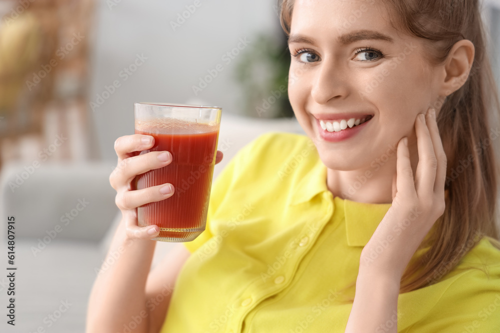 Sporty young woman with glass of vegetable juice in kitchen, closeup