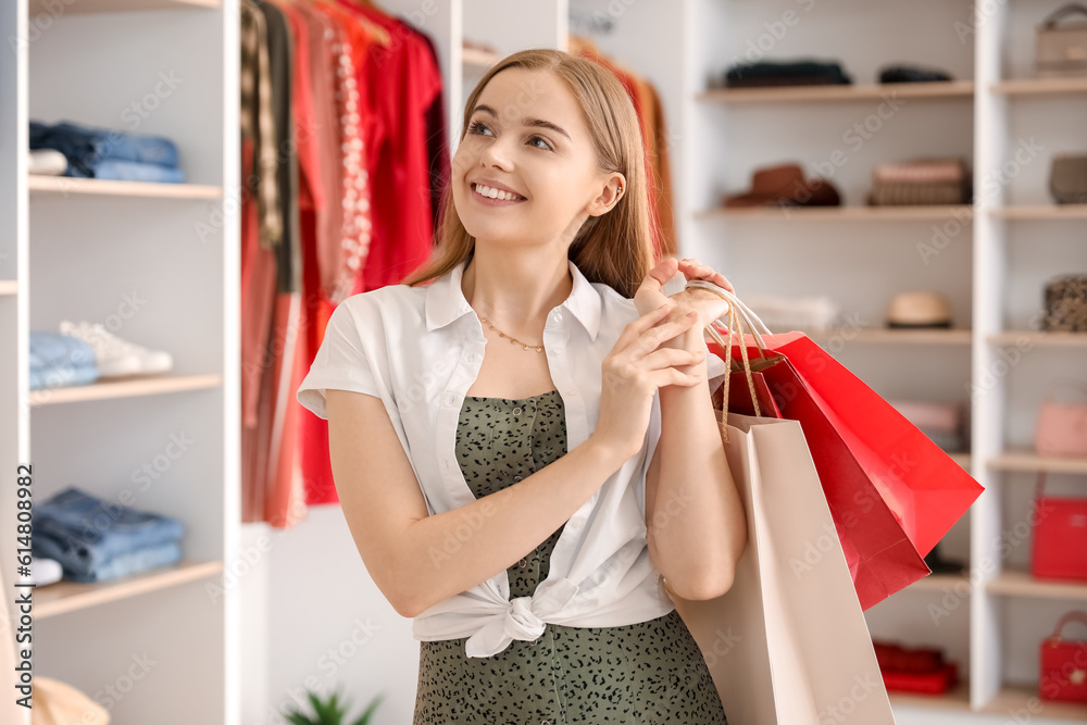 Young woman with shopping bags in boutique