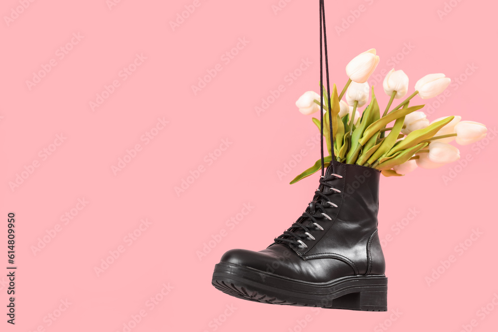 Tulip flowers in shoes on pink background