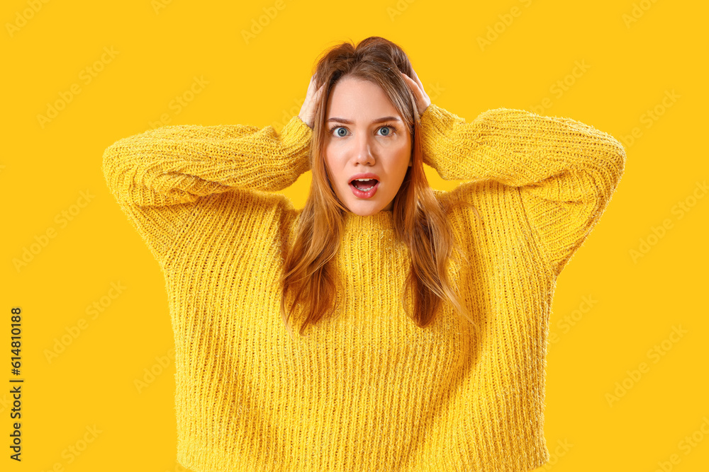 Shocked young woman on yellow background