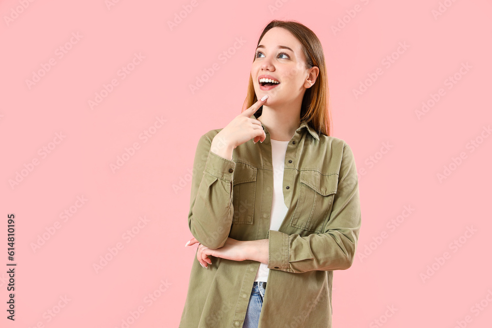 Thoughtful young woman on pink background