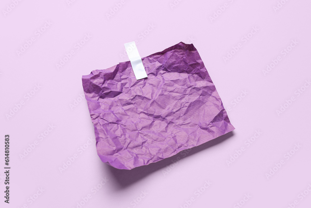 Crumpled paper sheet with adhesive tape on lilac background