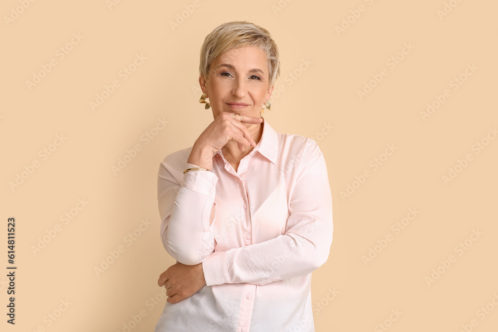 Mature blonde woman on beige background