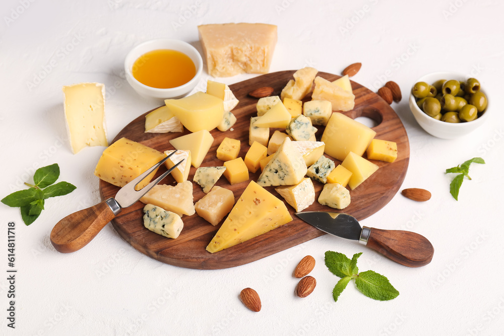 Wooden board with pieces of tasty cheese and honey on light background