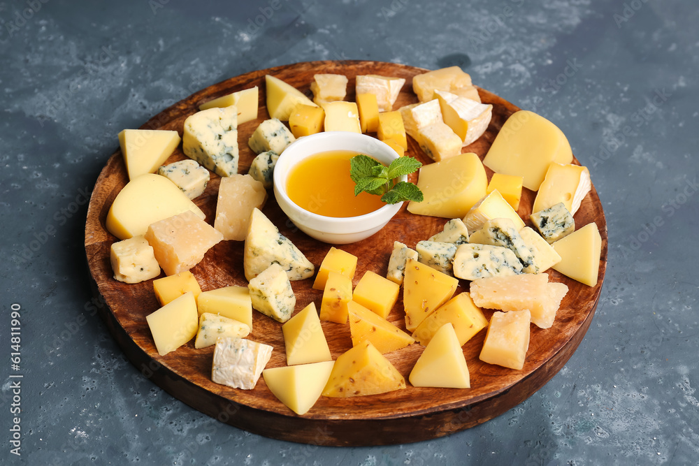 Plate with pieces of tasty cheese and honey on blue background