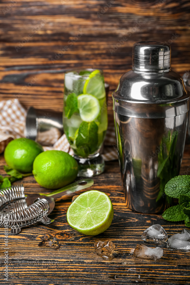 Shaker and ingredients for preparing mojito on wooden background