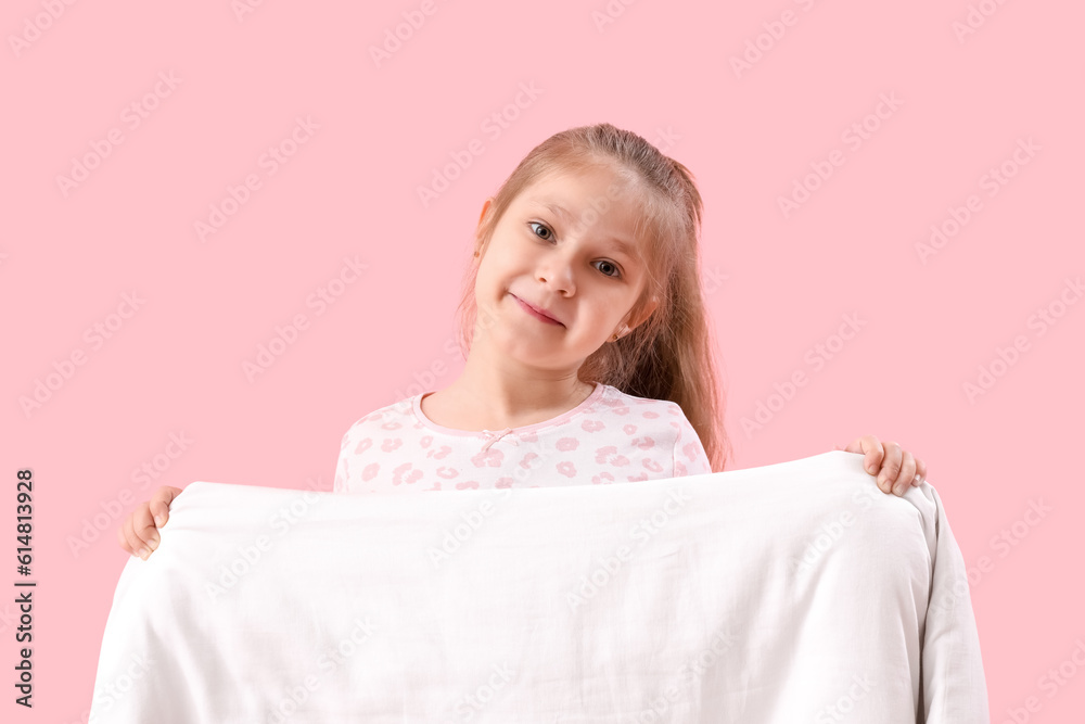 Little girl with soft blanket on pink background