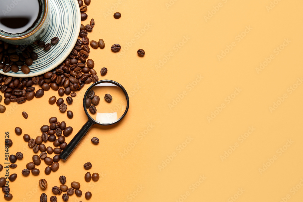 Magnifier and cup of coffee with beans on pale orange background