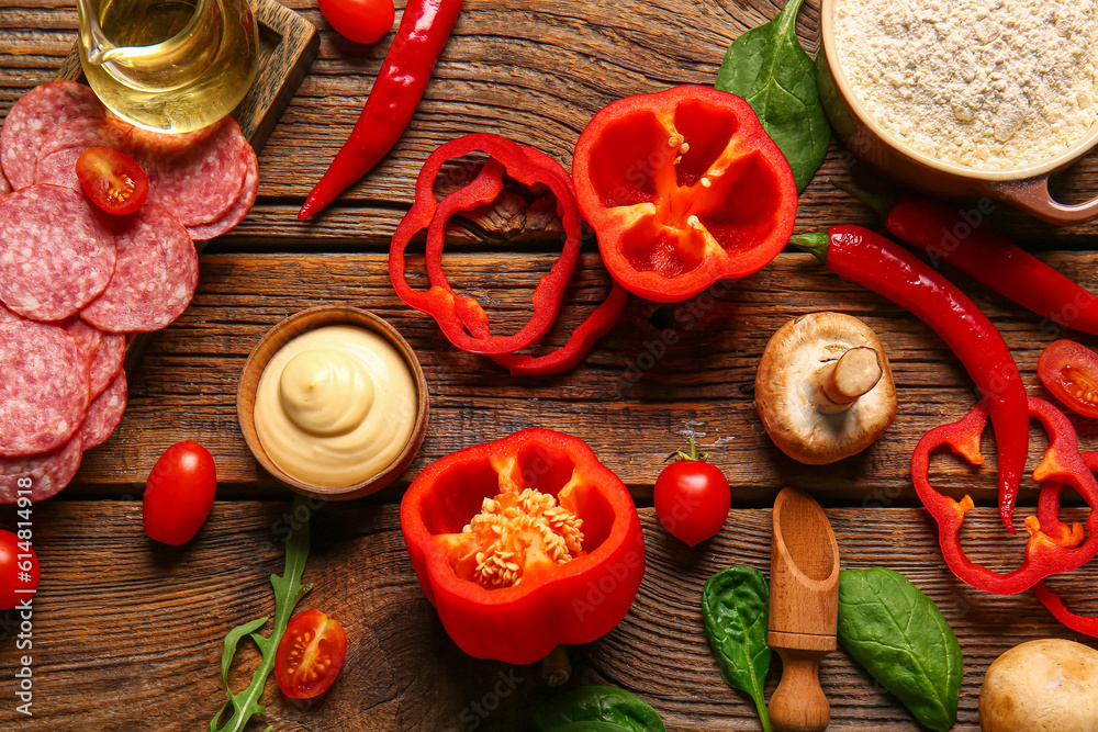 Different ingredients for preparing pizza on wooden background