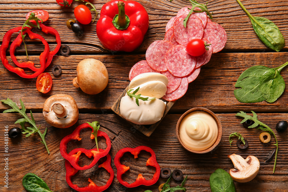 Different ingredients for preparing pizza on wooden background