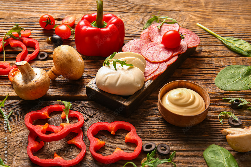 Different ingredients for preparing pizza on wooden background