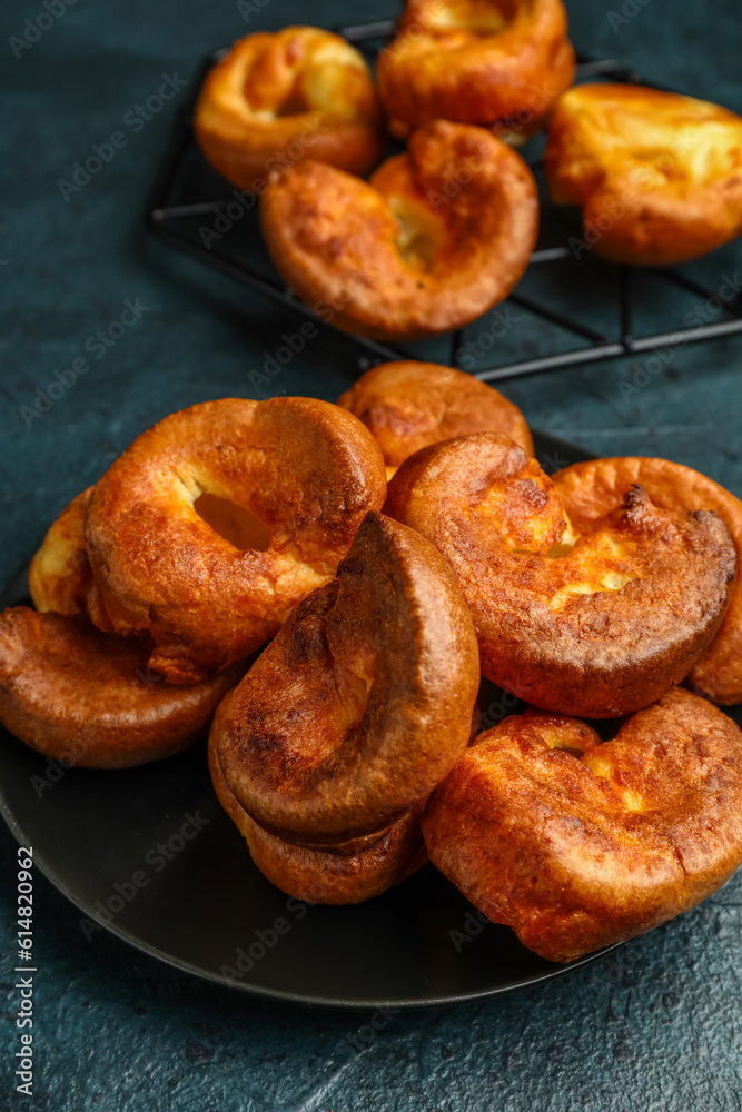 Plate with tasty Yorkshire pudding on blue background