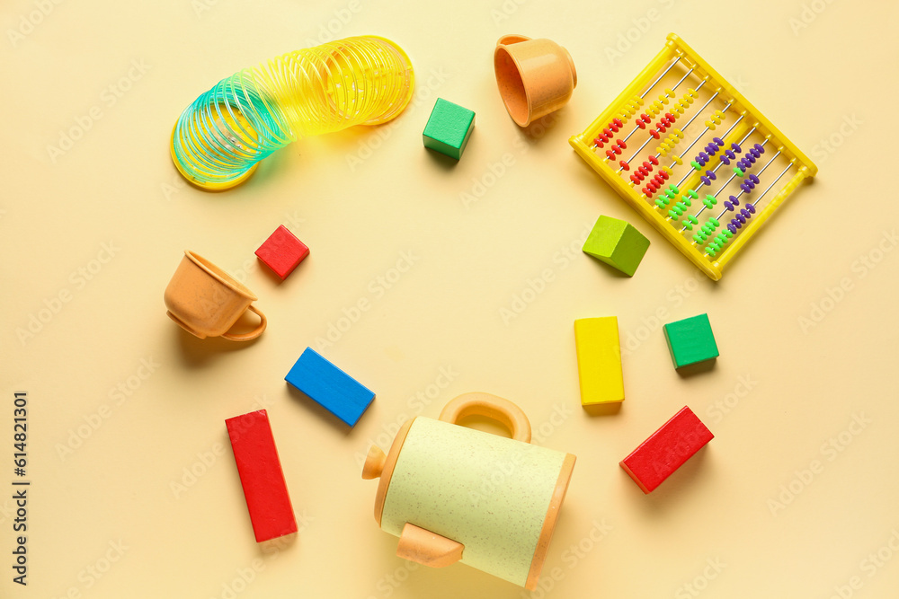 Frame made of different toys on pale yellow background. Childrens Day celebration