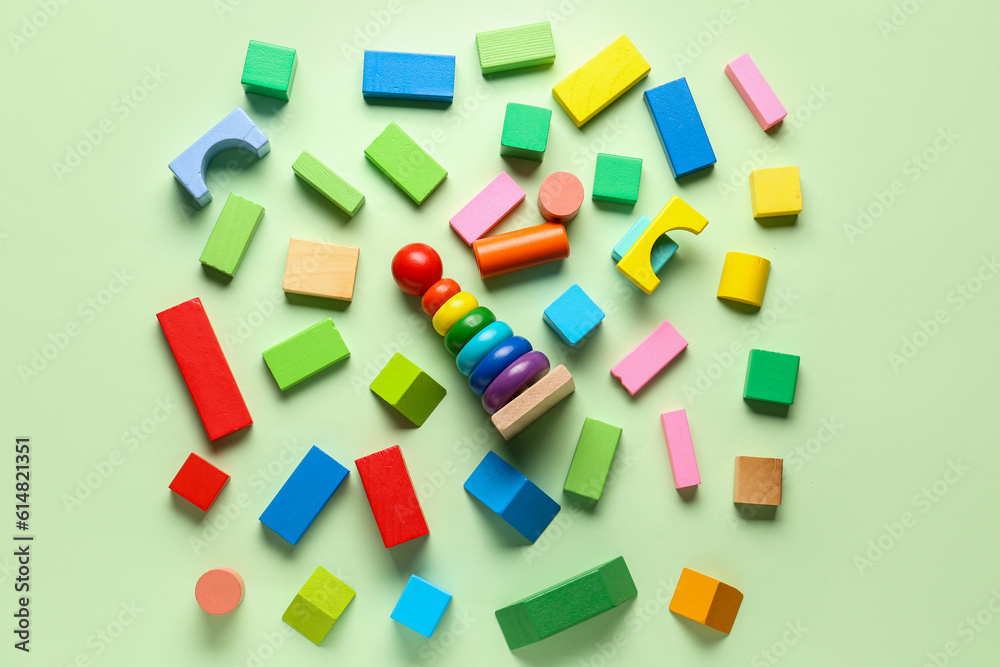 Wooden toy pyramid with colorful blocks on green background. Childrens Day celebration