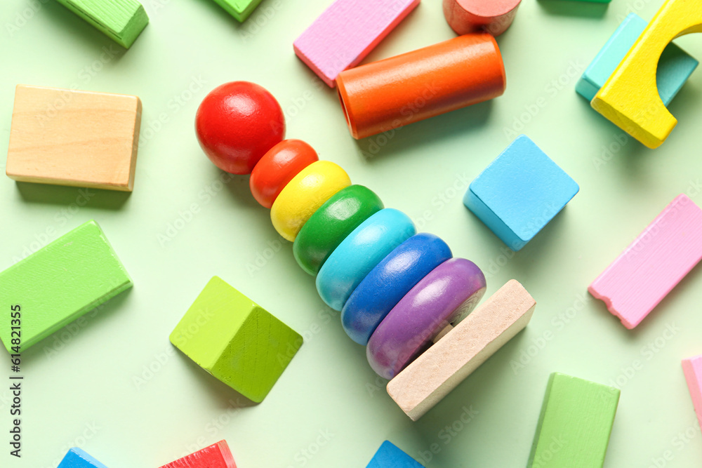 Wooden toy pyramid with colorful blocks on green background. Childrens Day celebration