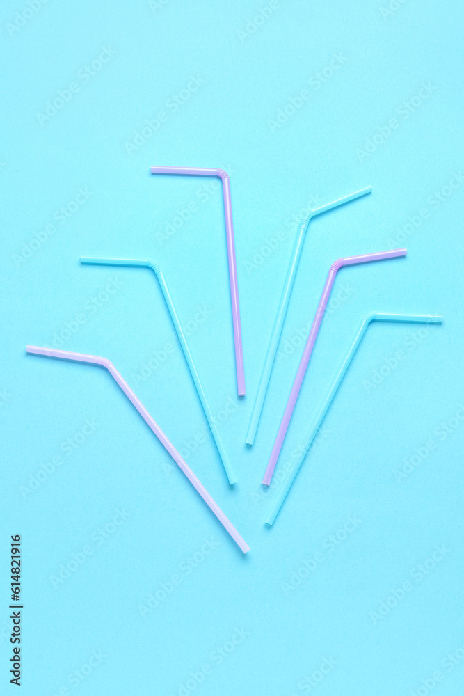 Different plastic straws on blue background