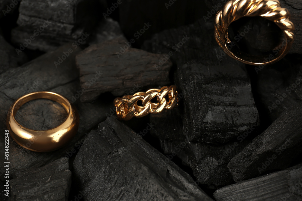 Beautiful rings on black charcoal, closeup