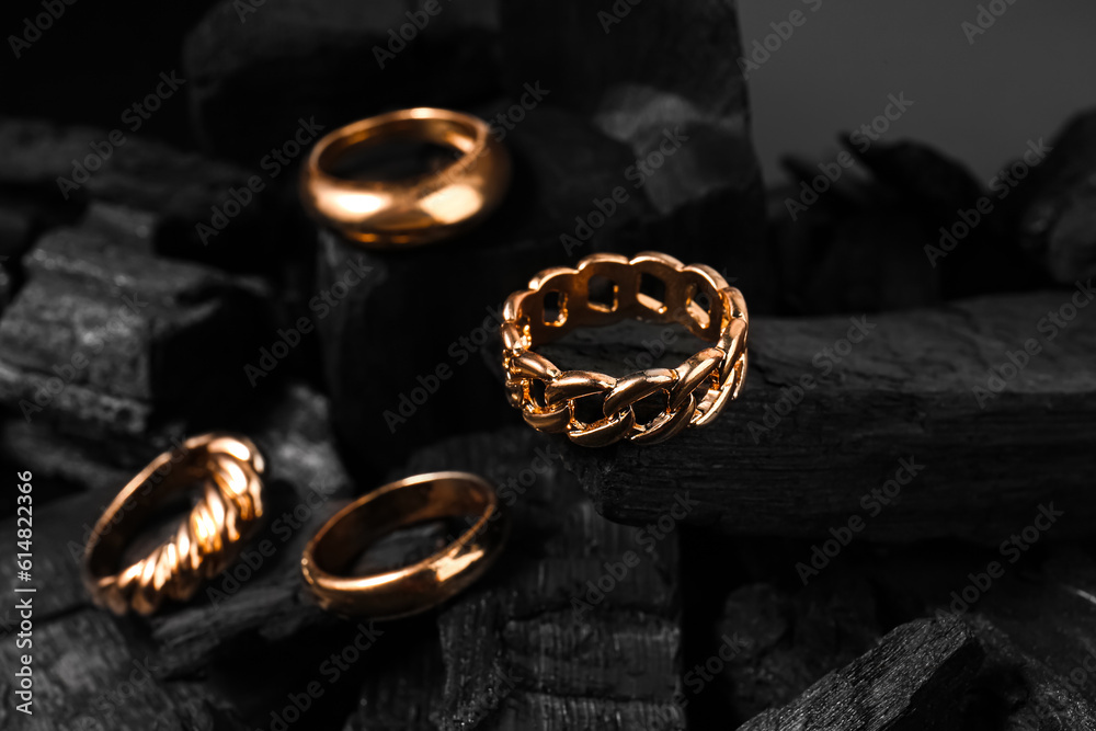 Beautiful rings on black charcoal, closeup