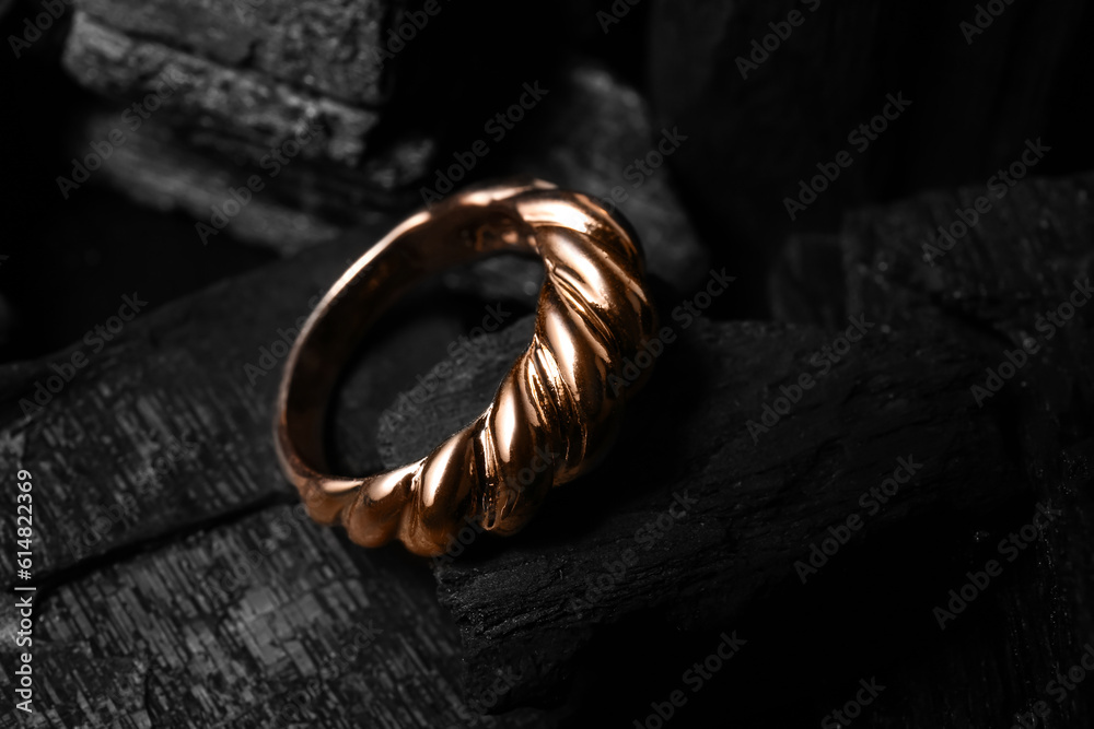 Beautiful ring on black charcoal, closeup