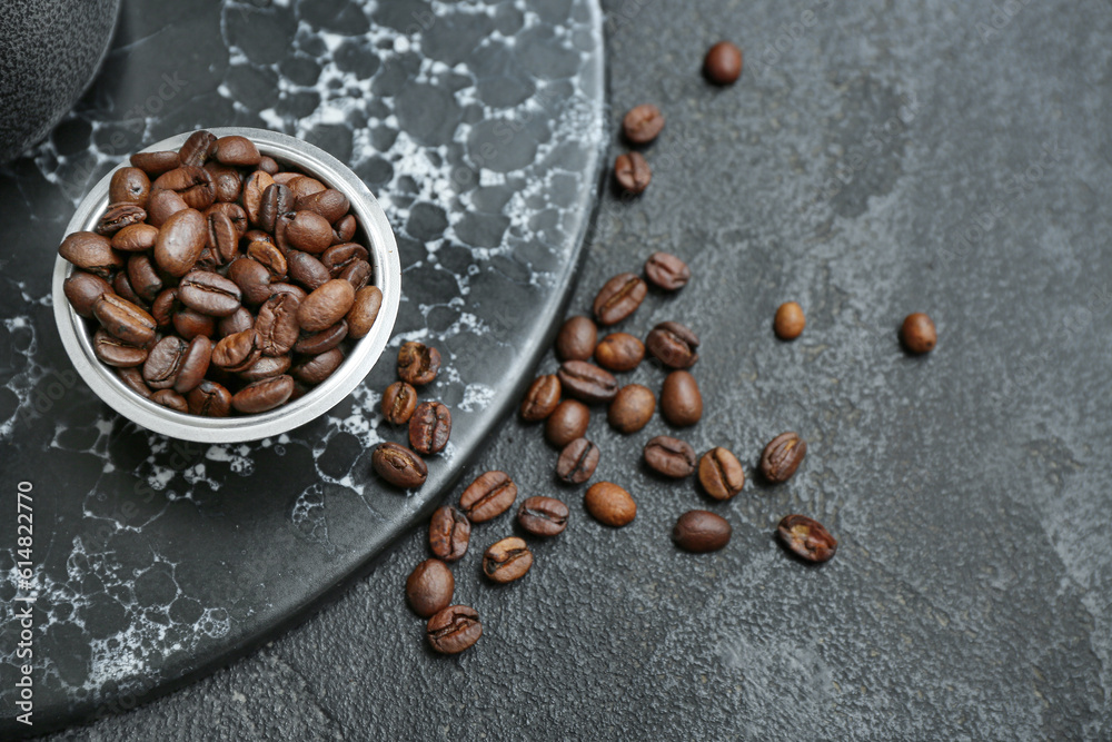 Bowl with coffee beans on black background