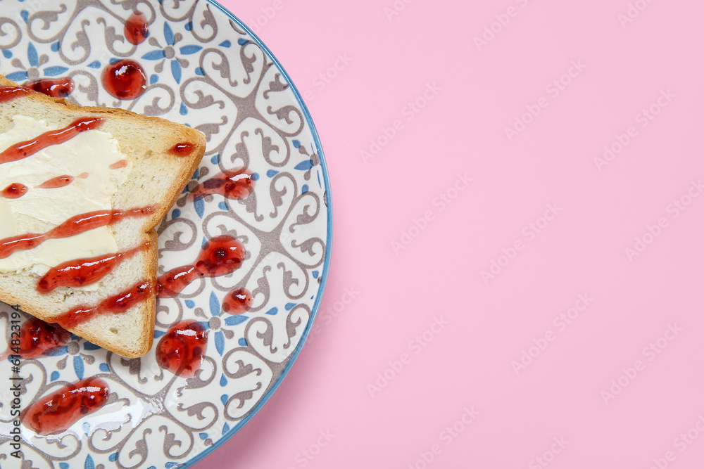 Plate of toast with butter and jam on pink background, closeup