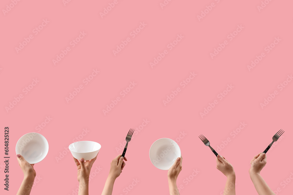 Female hands holding bowls and forks on pink background